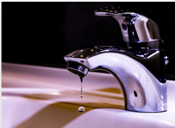 Plumber repairing a leaky faucet in a kitchen