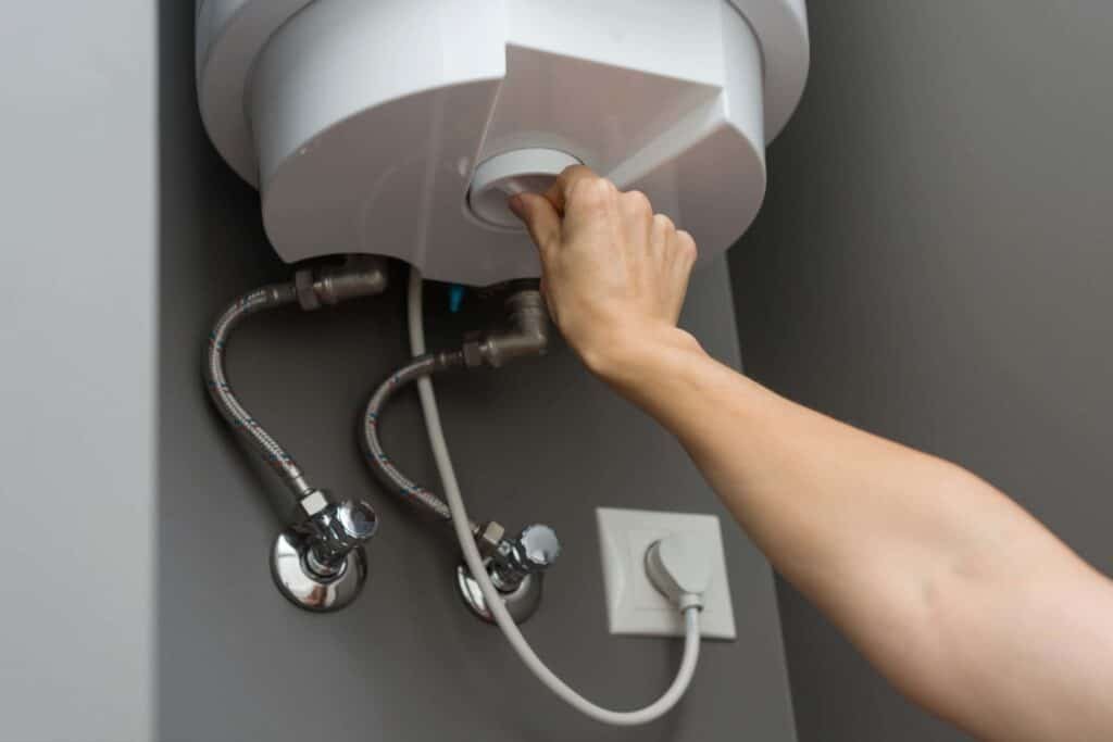 Woman adjusting water heater temperature using a digital control panel