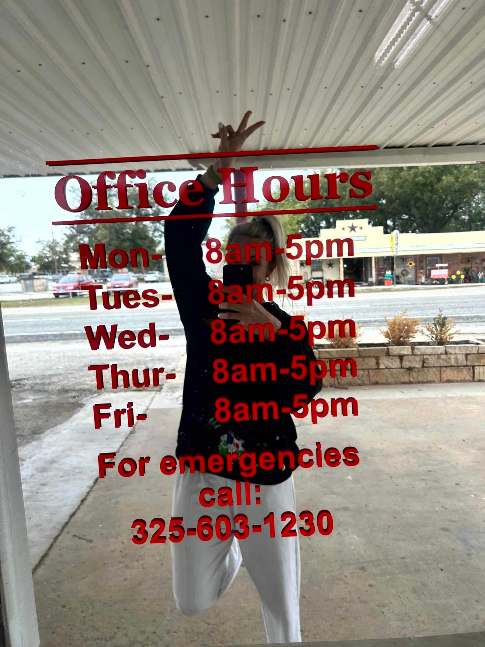 http://A%20glass%20window%20displaying%20On%20Point%20Plumbing’s%20office%20hours%20and%20emergency%20contact%20information,%20with%20a%20reflection%20of%20a%20team%20member%20taking%20a%20photo.